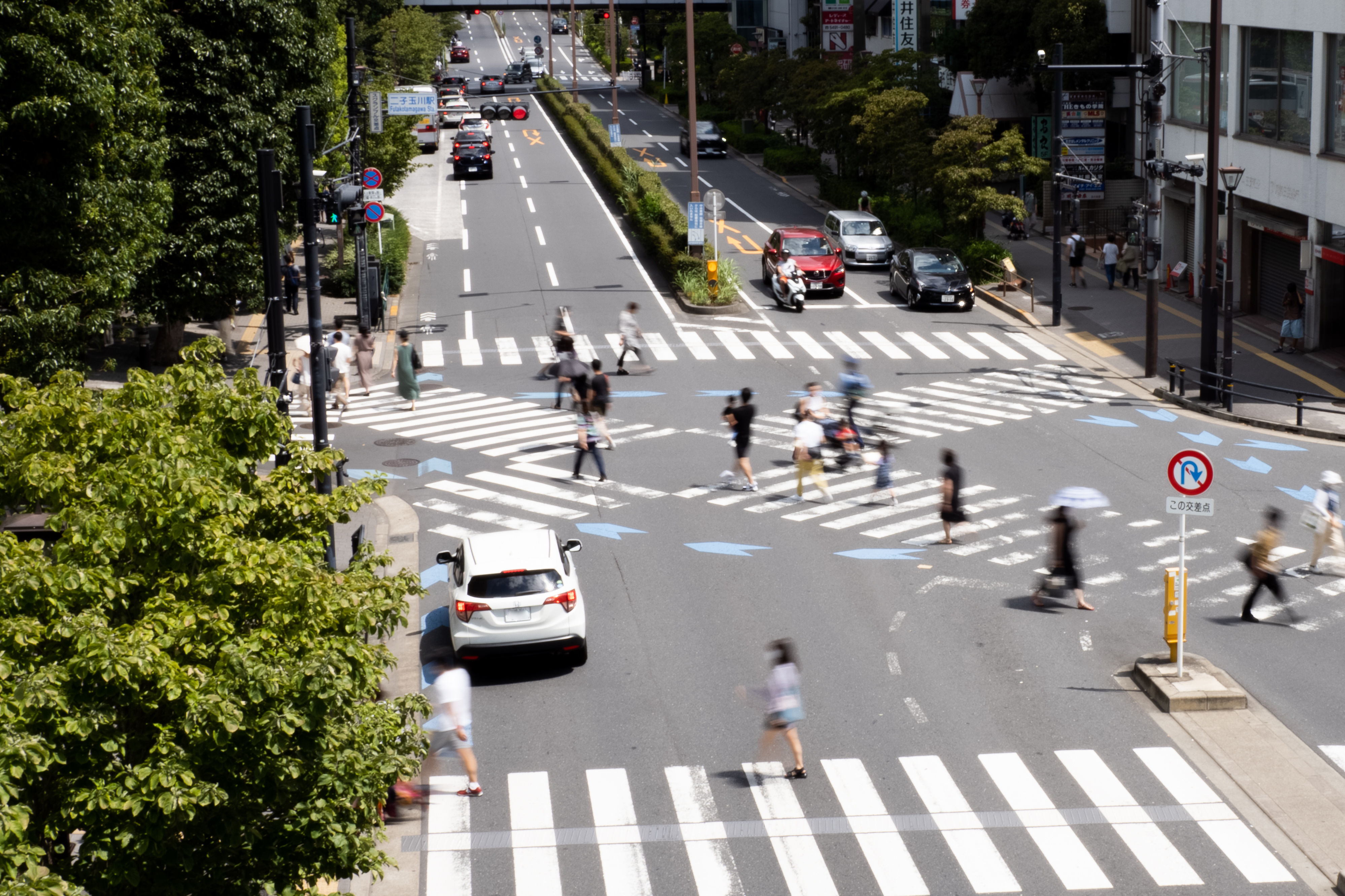 晴れた日の交差点で行き交う人々